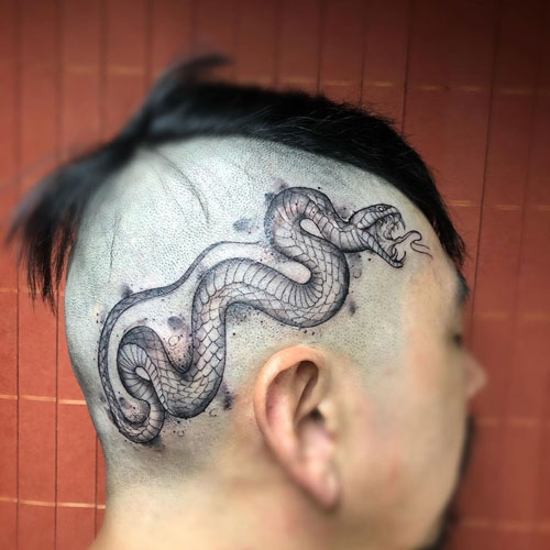 Serpiente tatuada en la cabeza