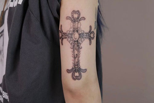 tatuaje de una cruz en el brazo