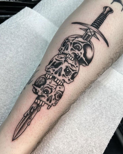 tatuaje espada y 3 craneos