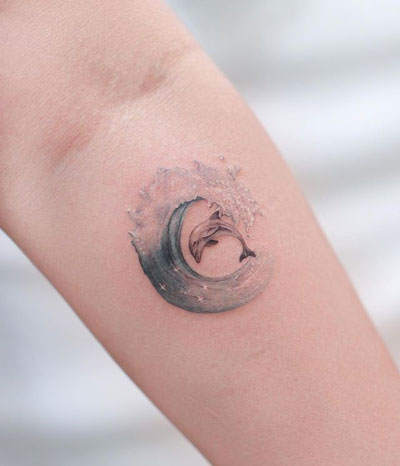 tatuaje delfin y ola