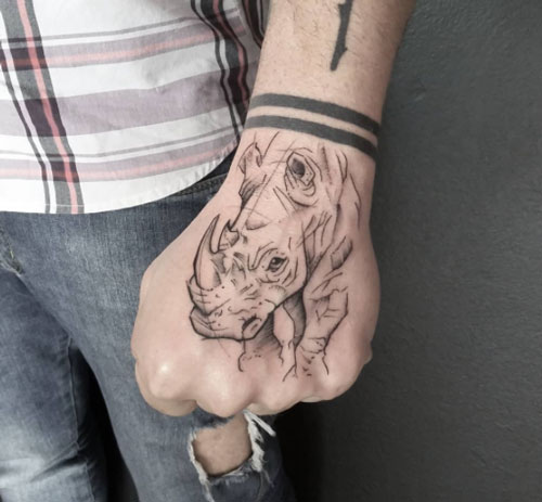 tattoo en la mano con rinoceronte