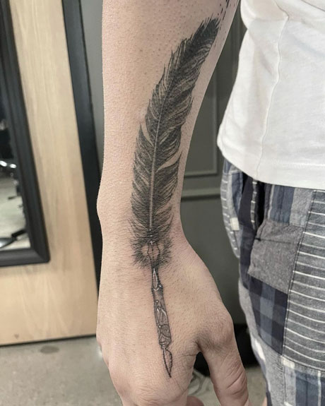 tatuaje de pluna en antebrazo