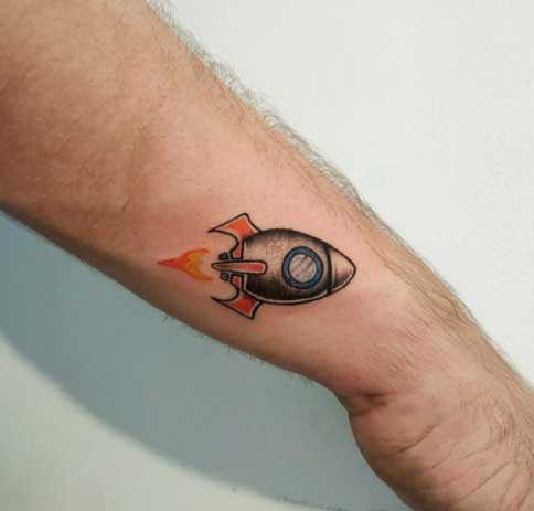 tatuaje a color de cohete pequeño